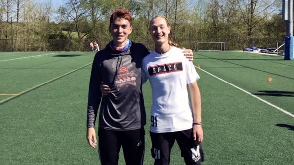 Two students standing on a playing field